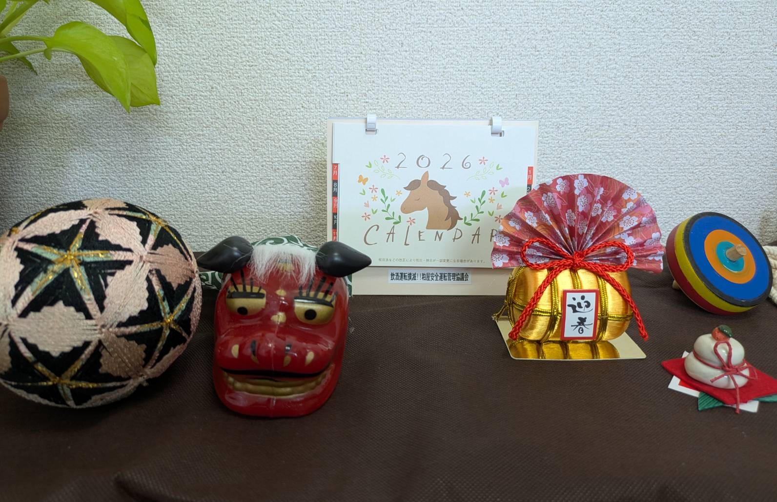 事務所入口に利用者様手作りの手鞠やししまい、こまや鏡餅のお正月のオーナメントを飾っている