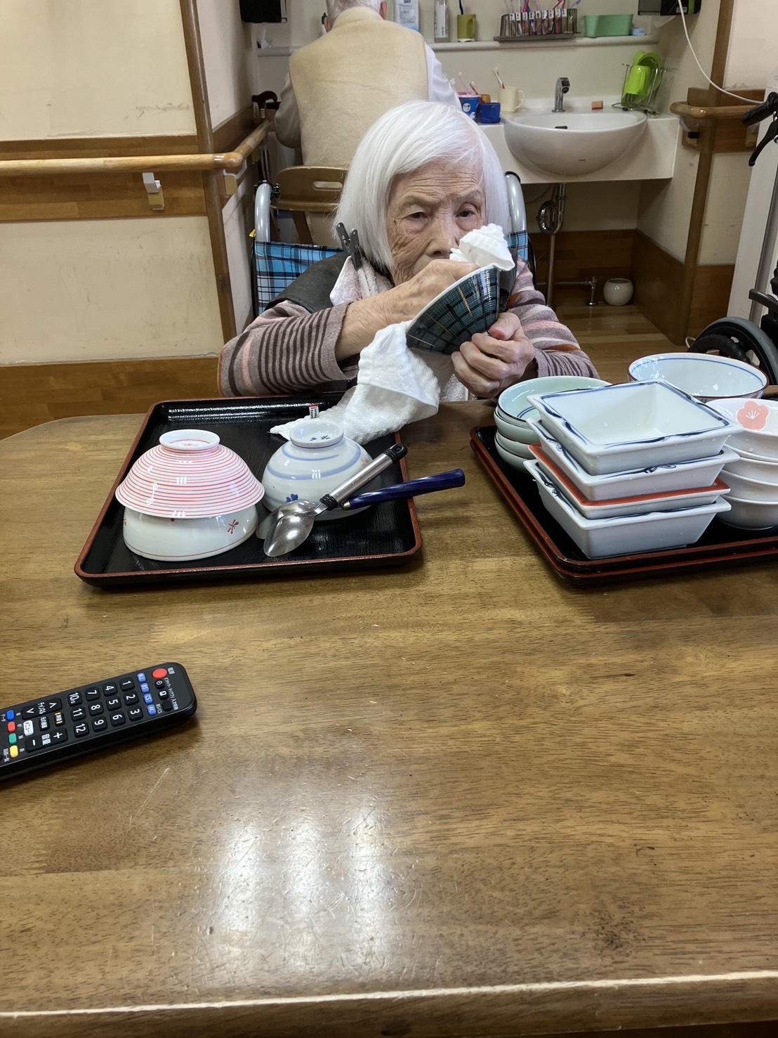 食器拭きを手伝う利用者さん