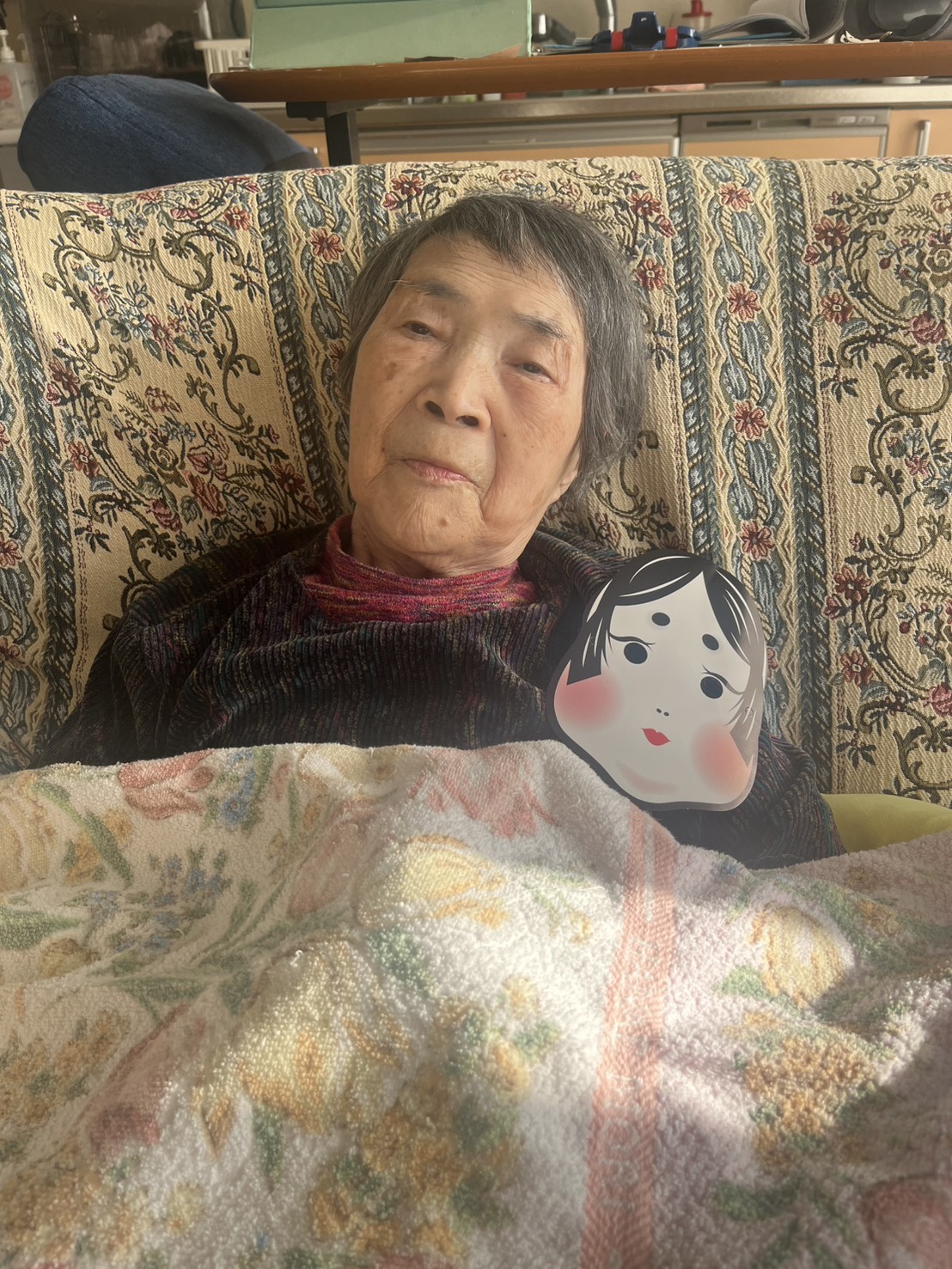 おかめの面と一緒に写る利用者さん