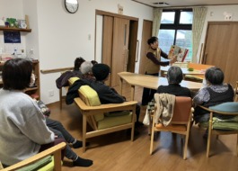 絵本を読み聞かせるボランティアさんとそれを聴く利用者さんたち