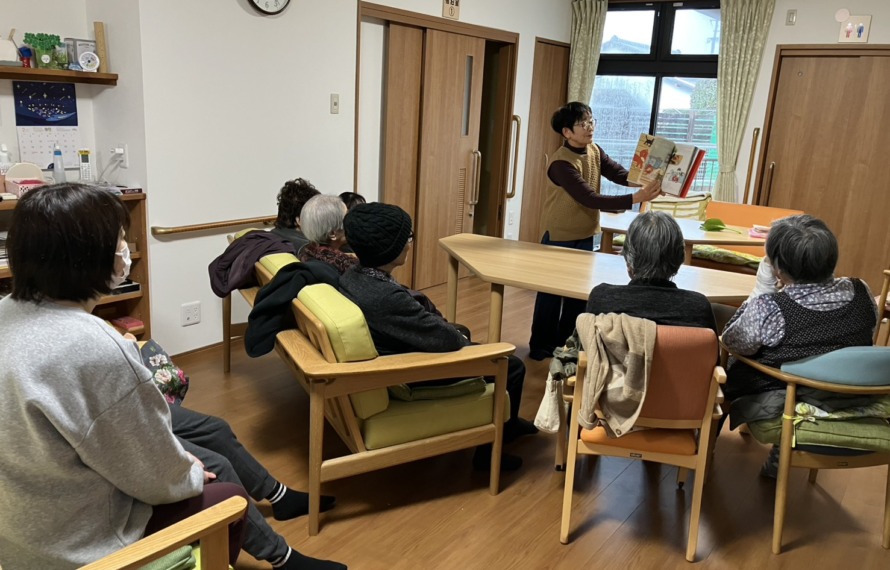絵本を読み聞かせるボランティアさんとそれを聴く利用者さんたち