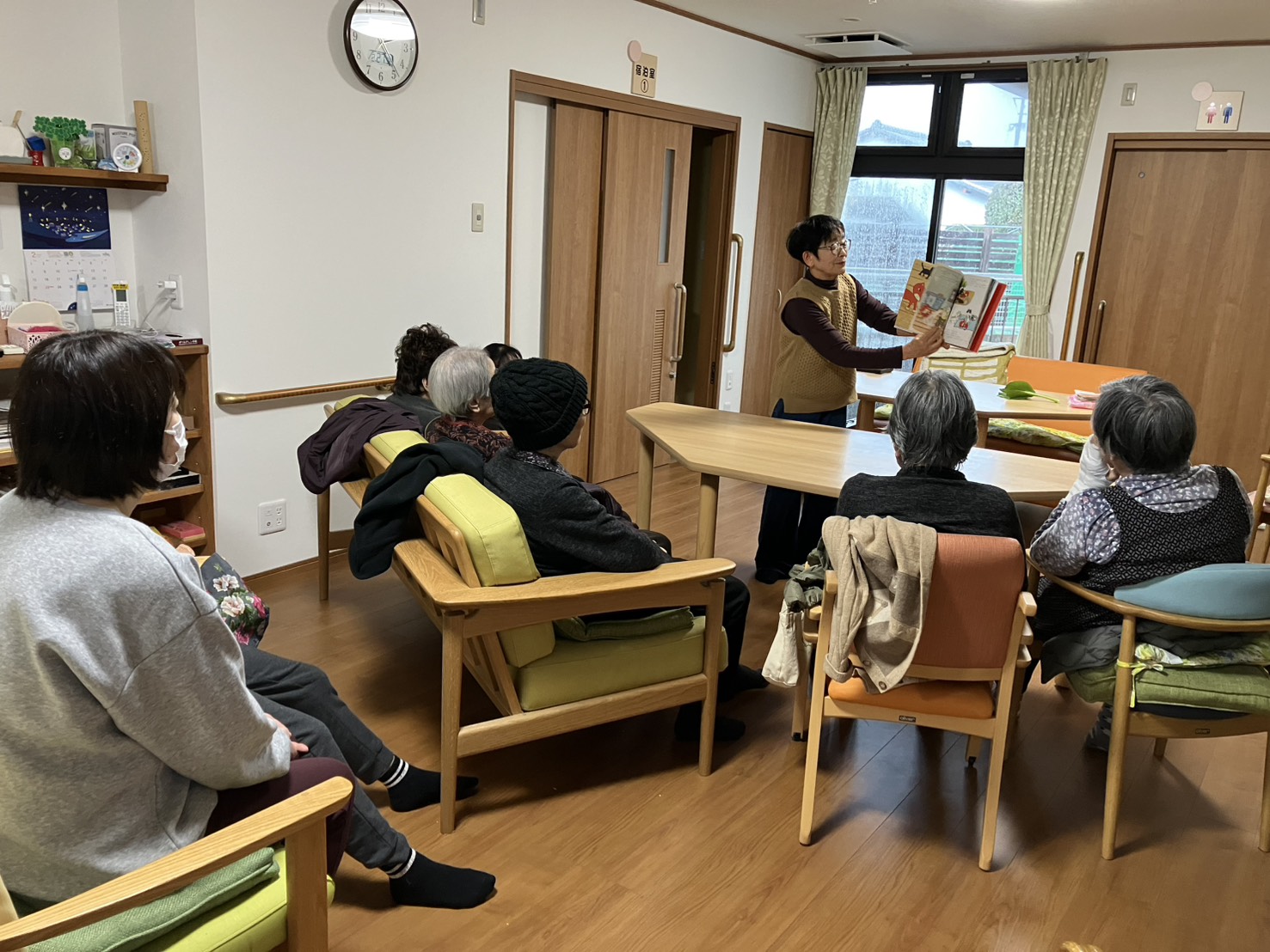 絵本を読み聞かせるボランティアさんとそれを聴く利用者さんたち