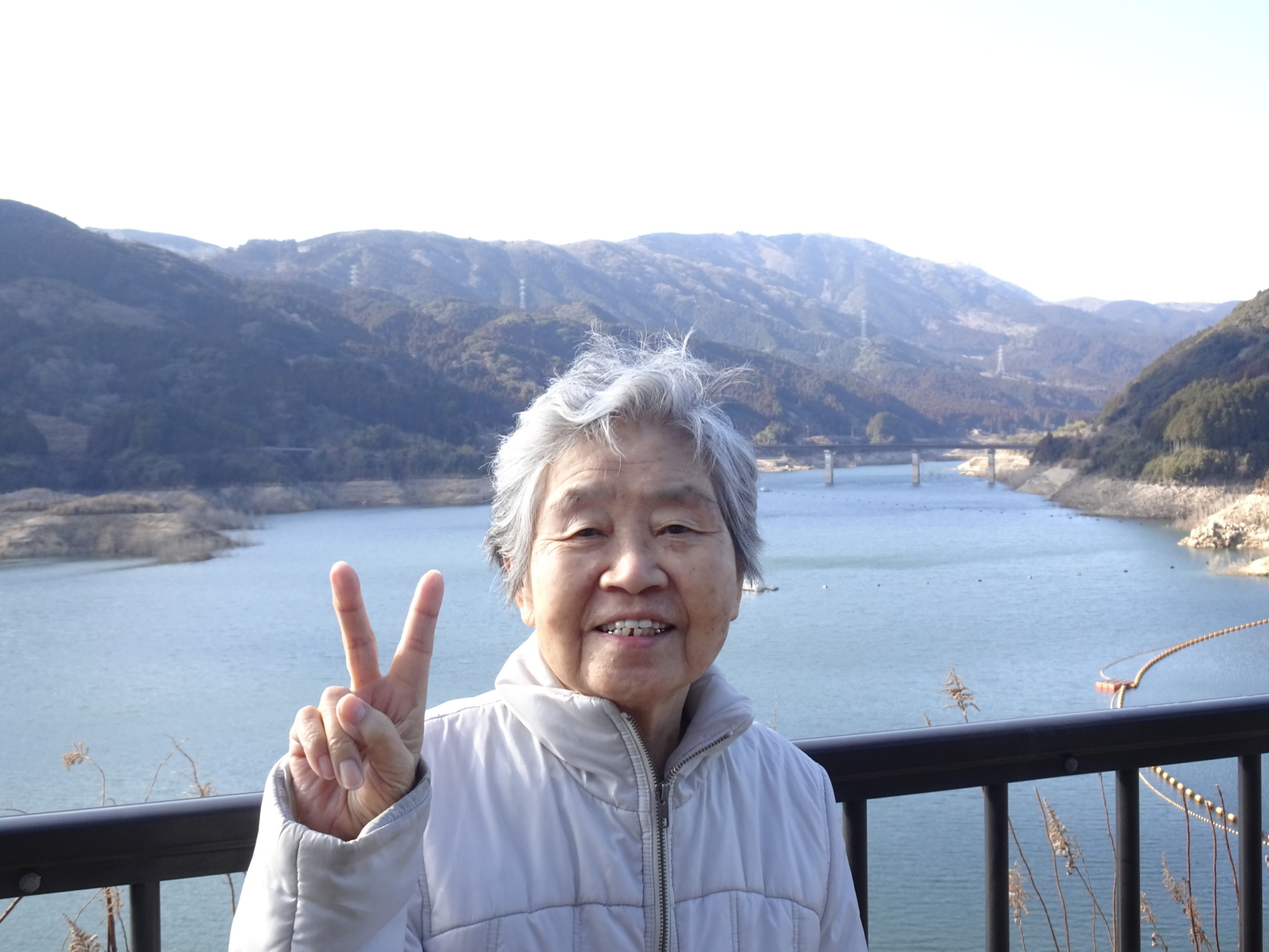 五ケ山ダムで山をバックに写る利用者さん