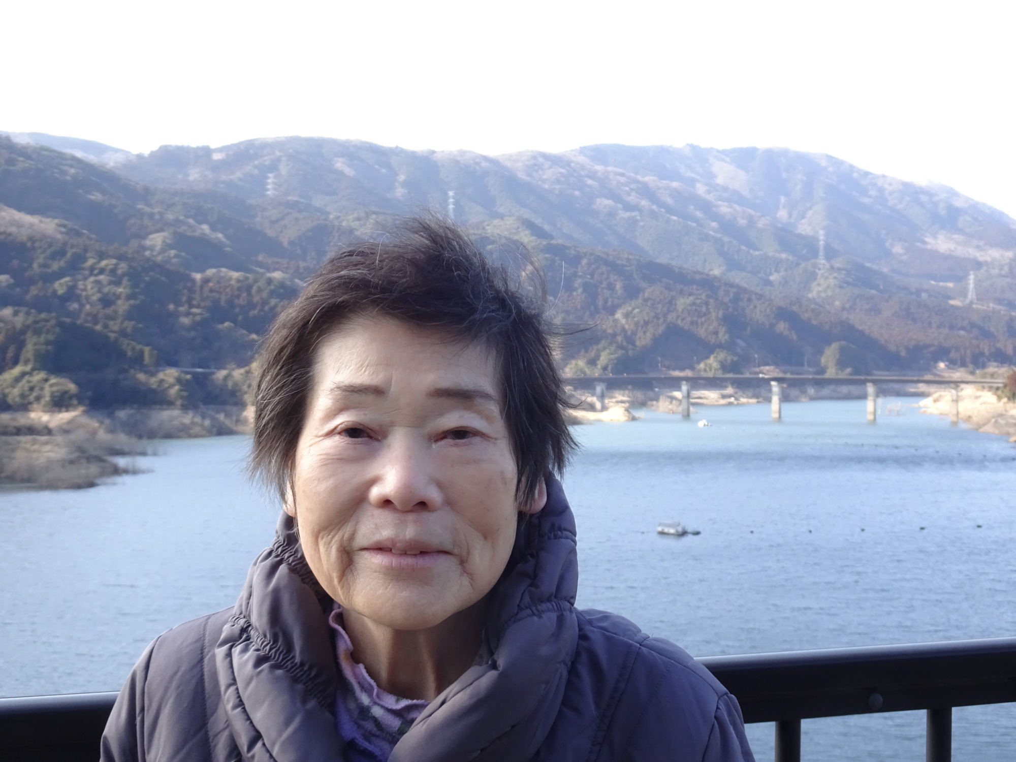 五ケ山ダムで山をバックに写る利用者さん