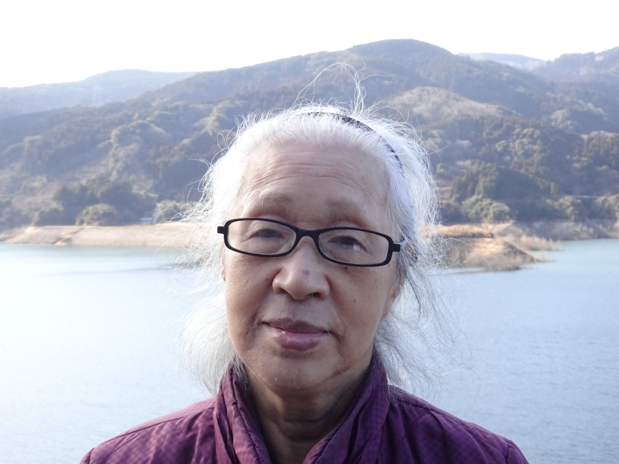 五ケ山ダムで山をバックに写る利用者さん