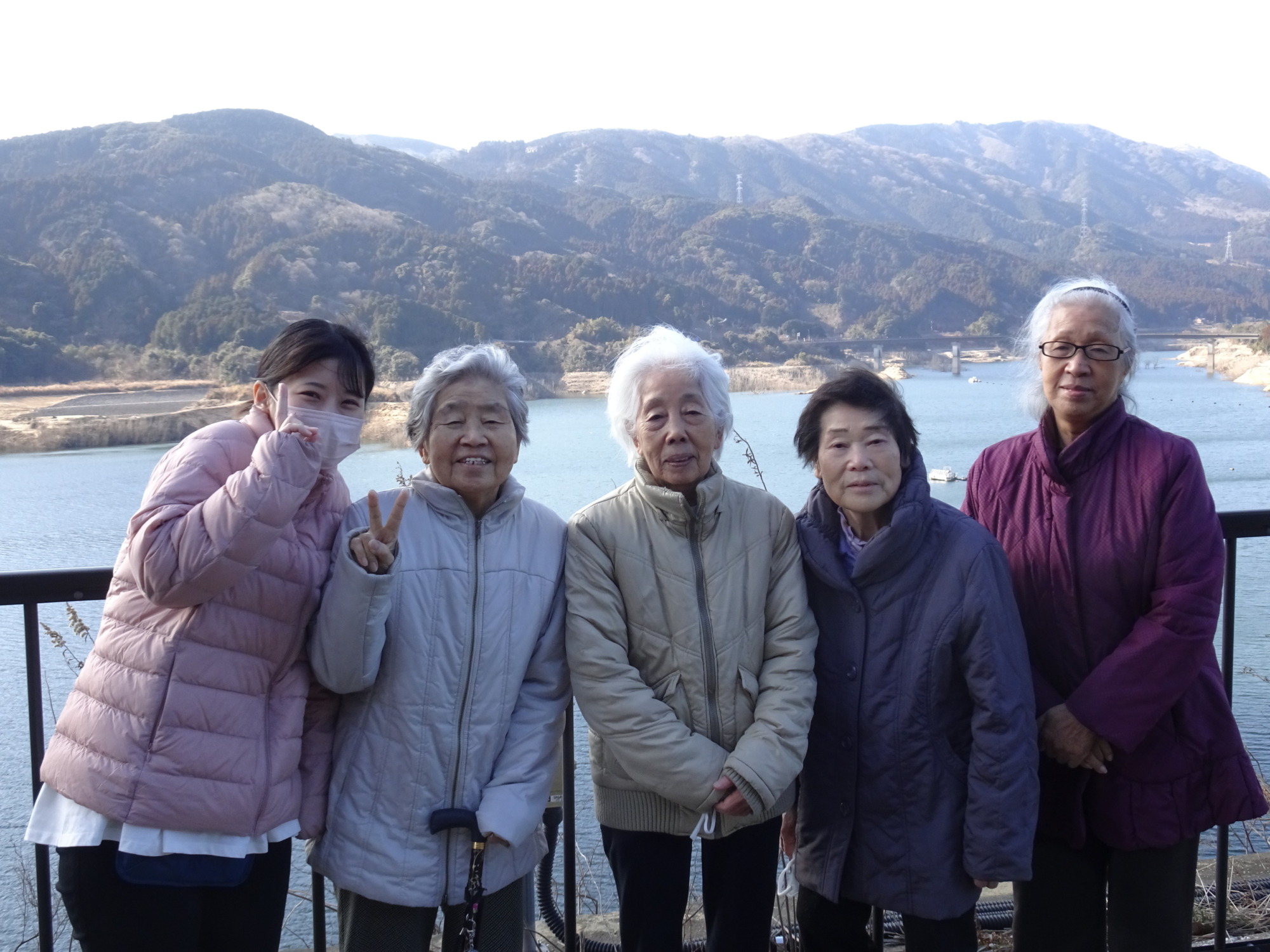 五ケ山ダムで山をバックに写る利用者たちとワーカー