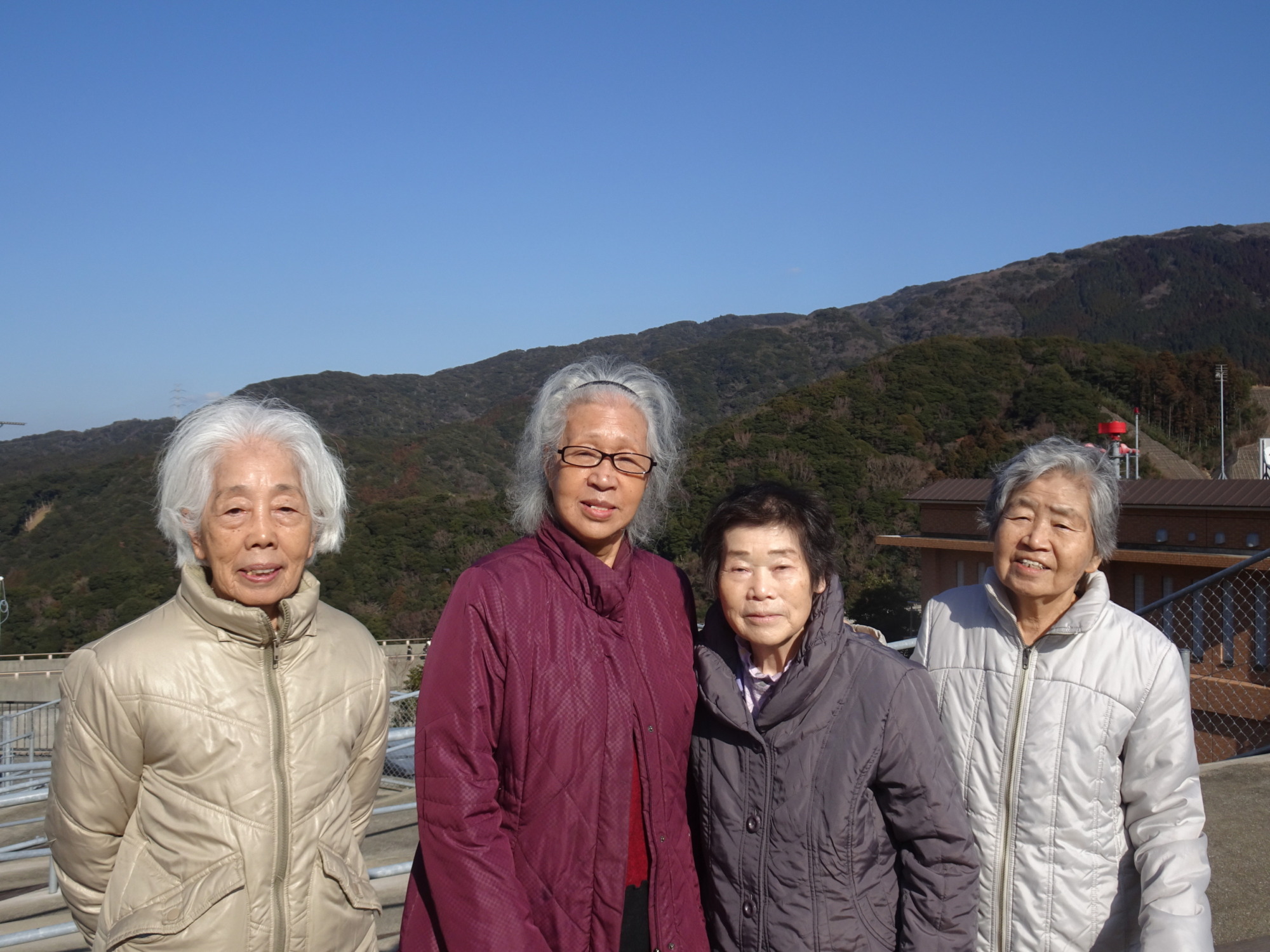 五ケ山ダムで山をバックに写る利用者たち