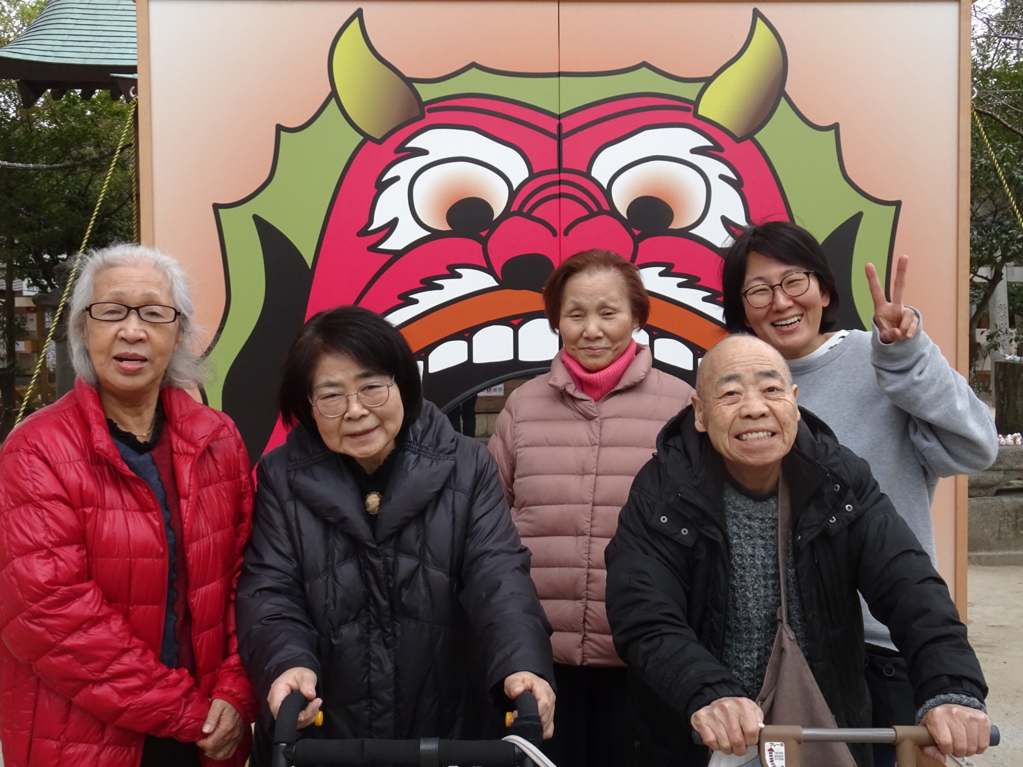 現人神社の鬼くぐりの前で撮った利用者さんたちとワーカーの写真