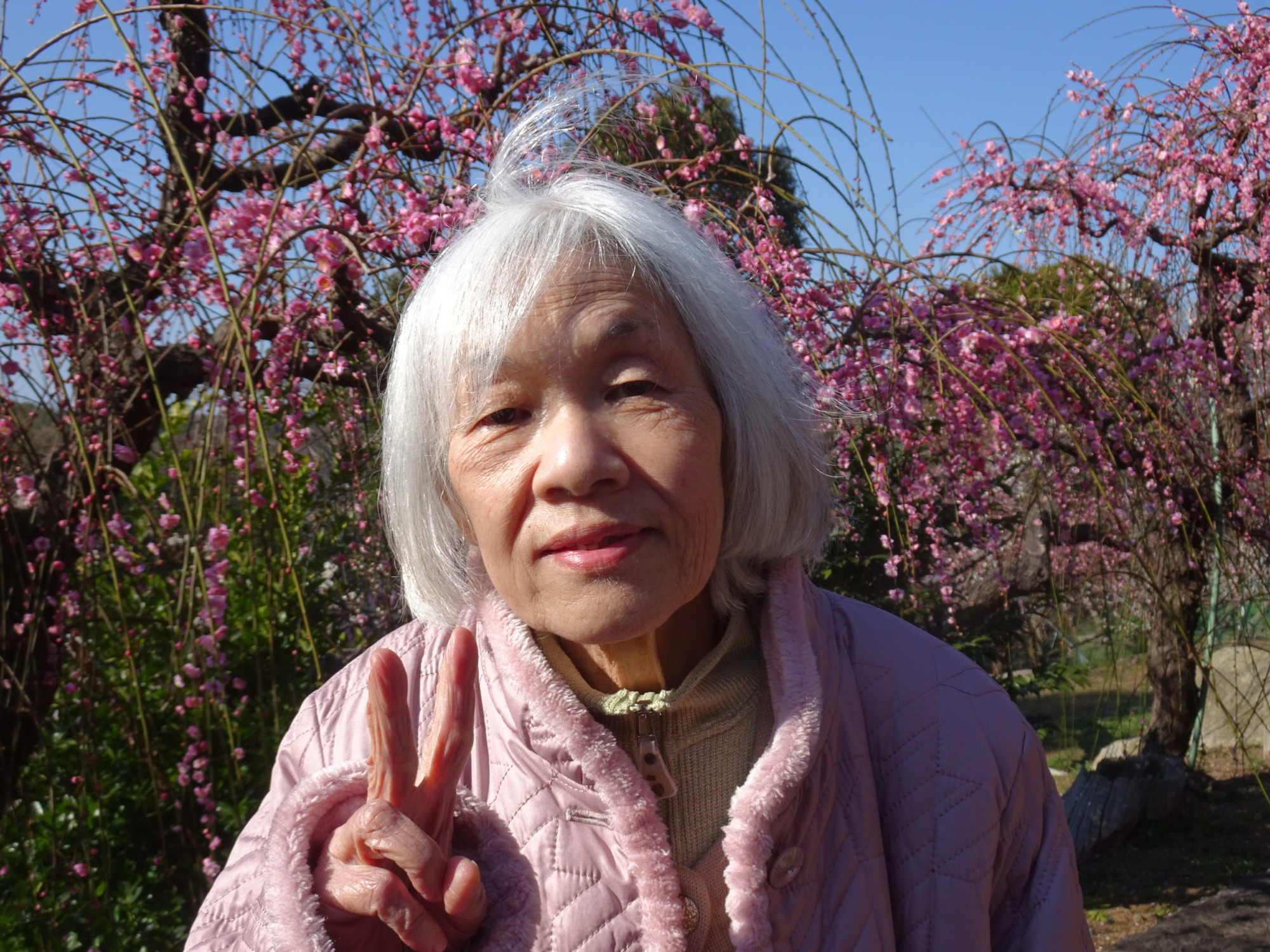 梅の木の前で撮った女性利用者さんの写真