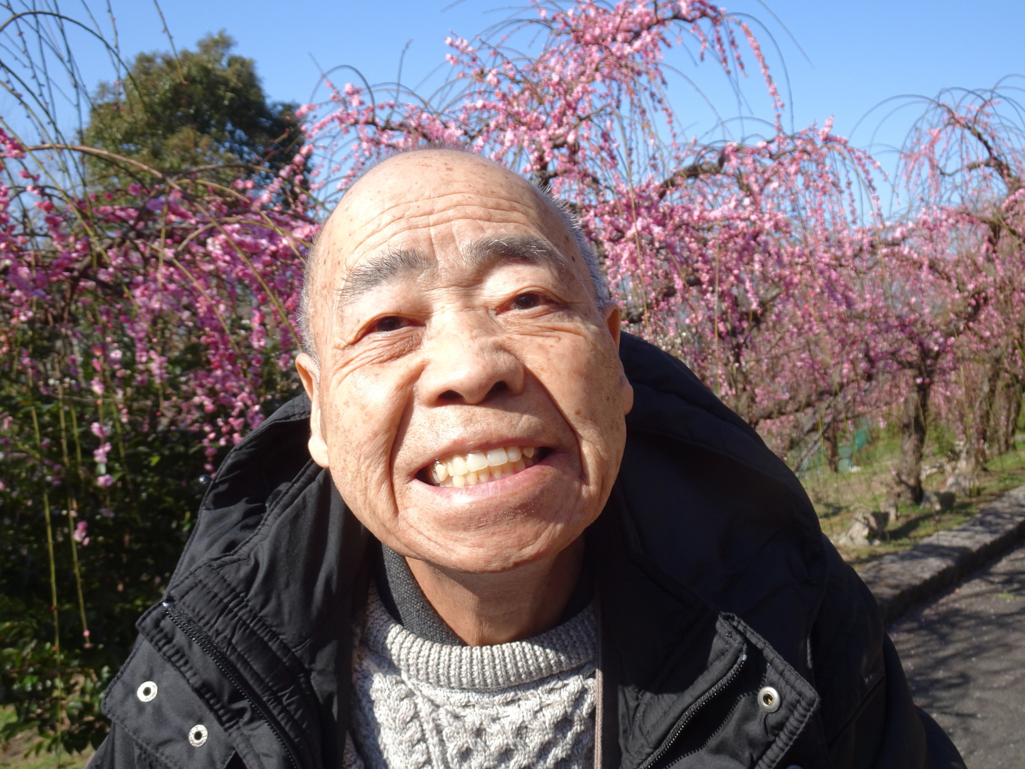 梅の木の前で撮った男性利用者さんの写真