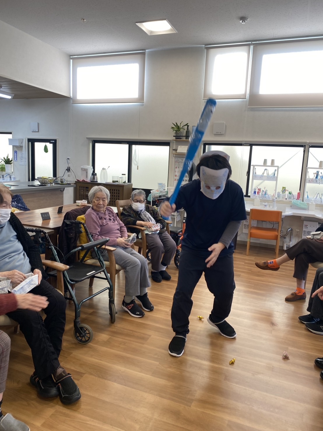 鬼役の男性スタッフに豆まきをしている高齢者