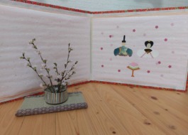 ワーカーの子どもが通う幼稚園の一角にお雛様と早咲きの品種の啓翁桜が飾られている
