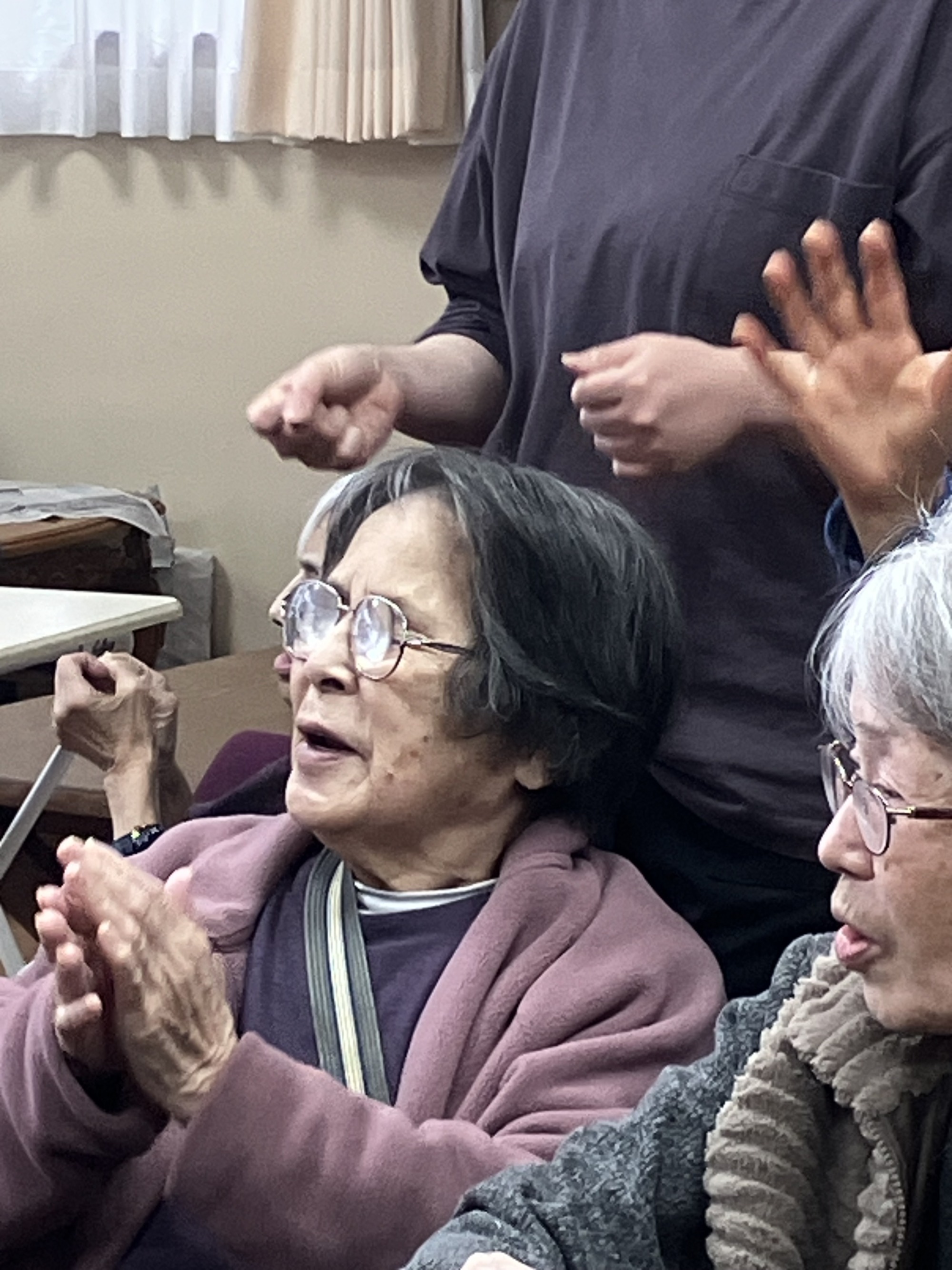歌に合わせて手拍子する利用者さん