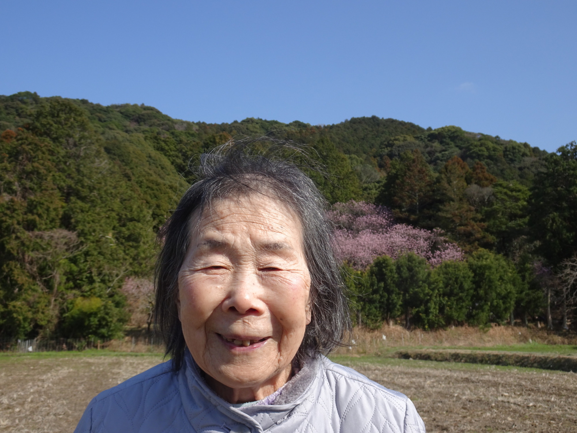 桜の前で撮った笑顔の利用者さん
