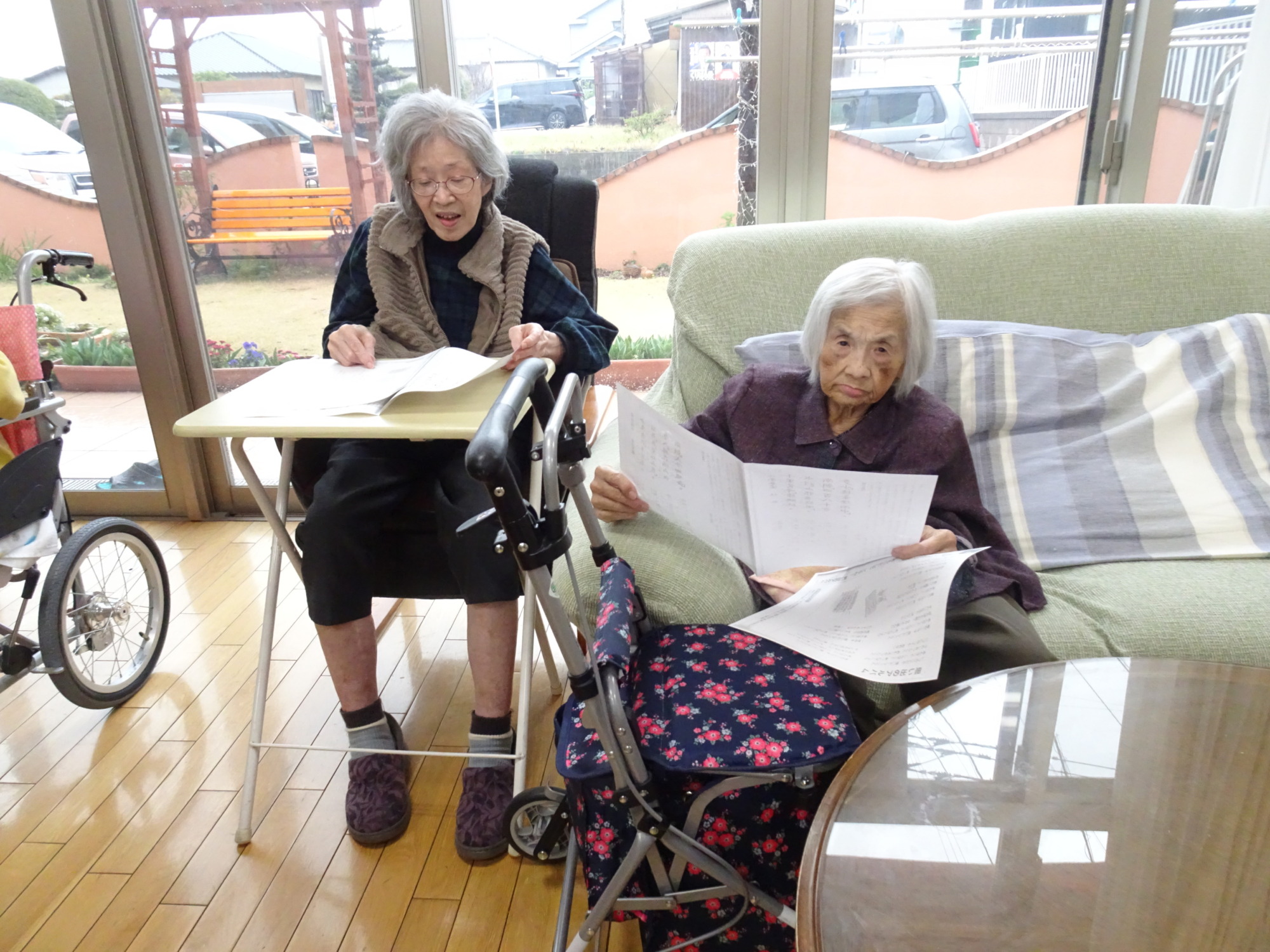 歌詞カードを見ながら一緒に歌う利用者さんたち