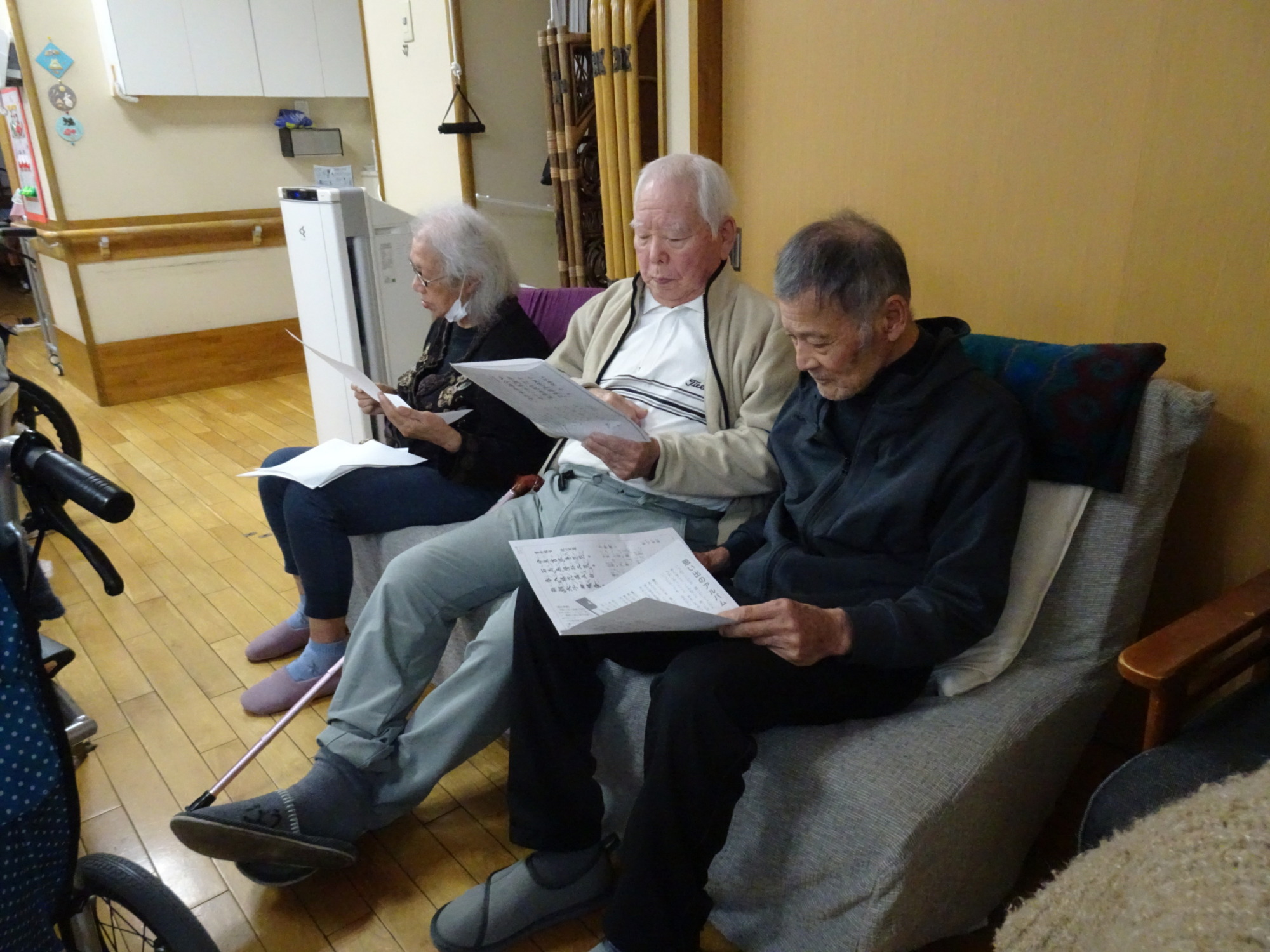 歌詞カードを見ながら一緒に歌う利用者さんたち