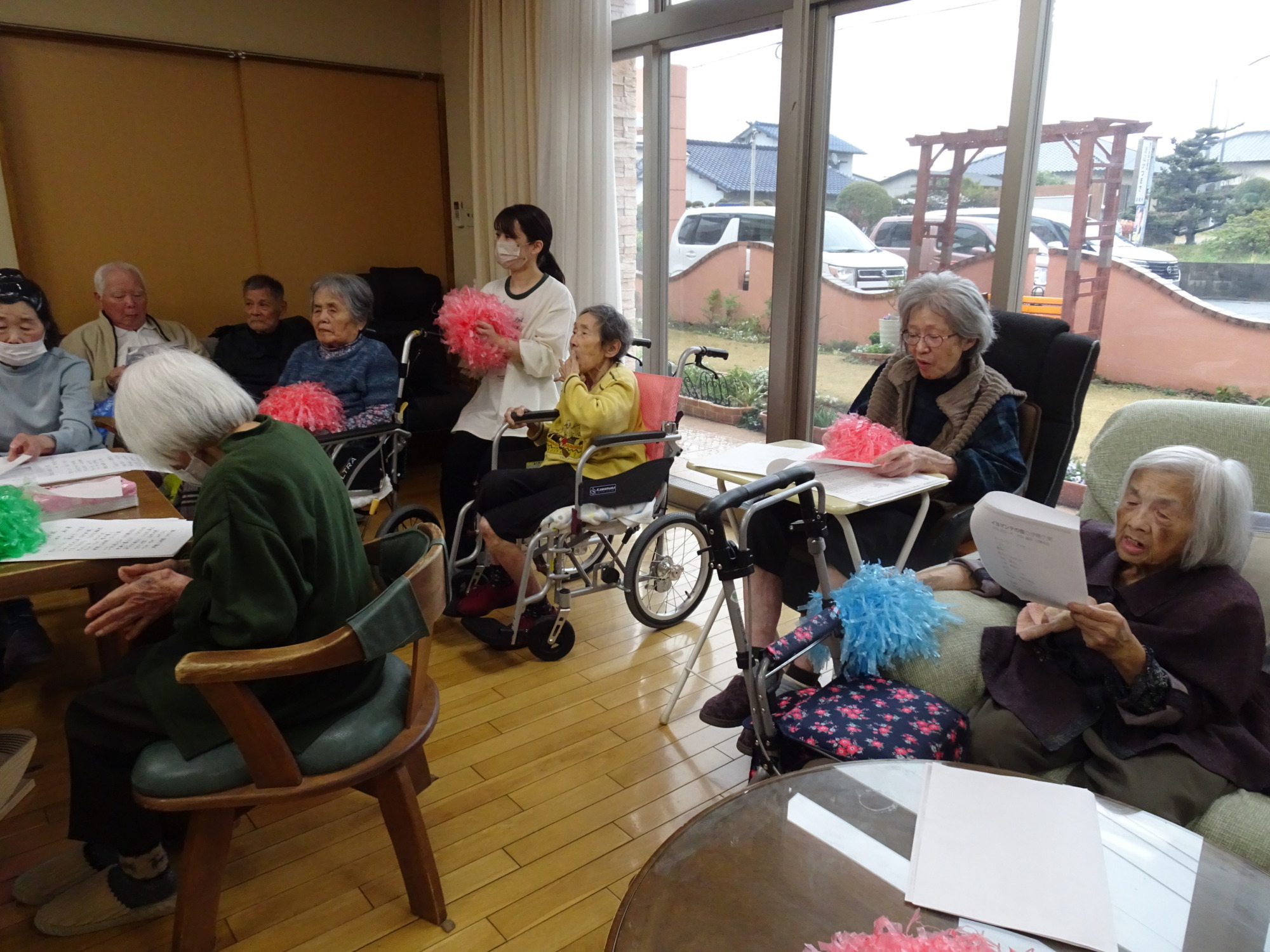 ポンポンを持って歌を聴く利用者さんたち