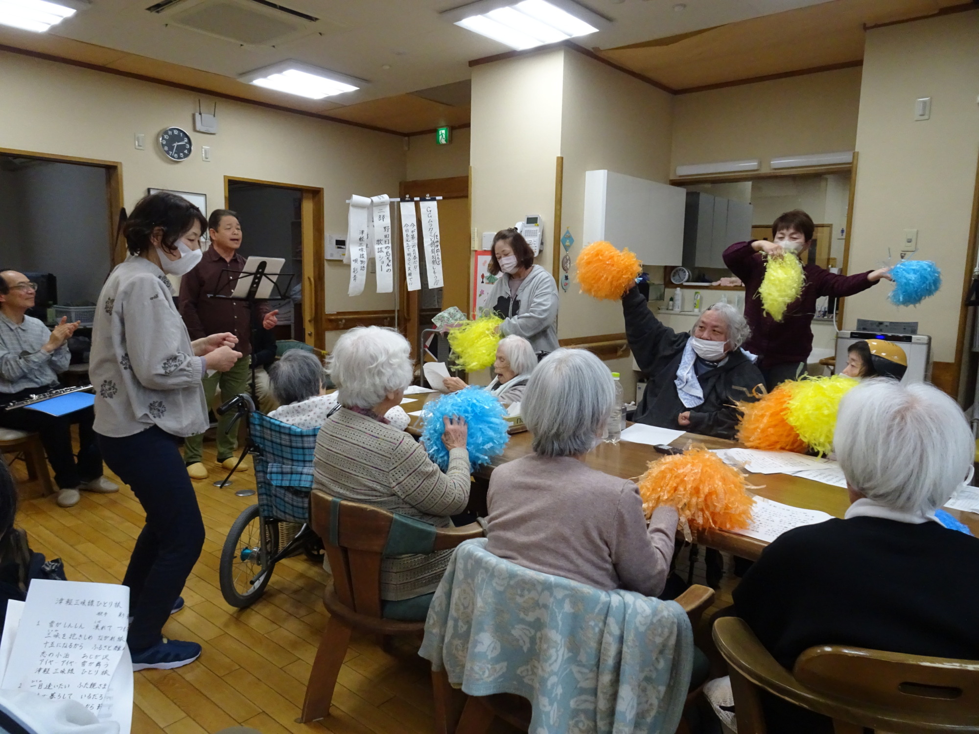 島ちゃんの歌に合わせてポンポンを振る利用者さんたち