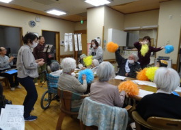 島ちゃんの歌に合わせてポンポンを振る利用者さんたち
