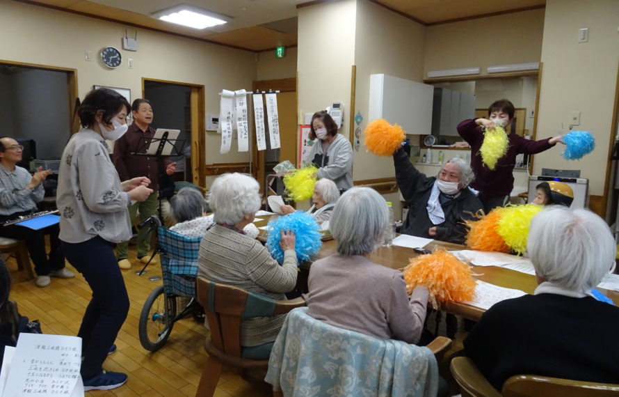 島ちゃんの歌に合わせてポンポンを振る利用者さんたち