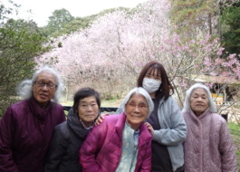 桜の前で撮った利用者さんたちとワーカーの写真