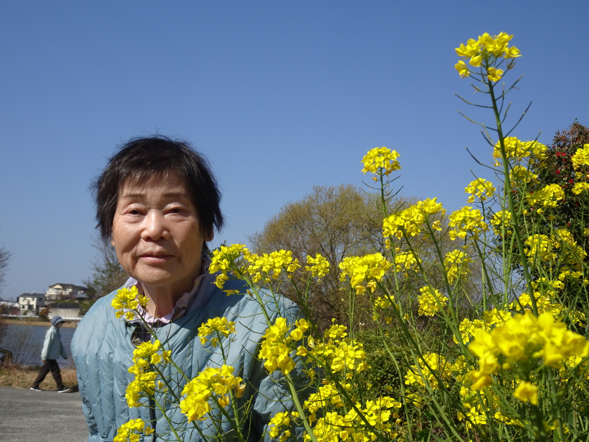 菜の花と一緒に写る利用者さん