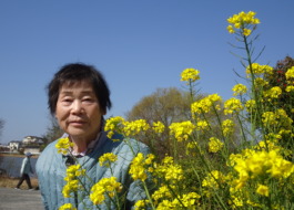 菜の花と一緒に写る利用者さん