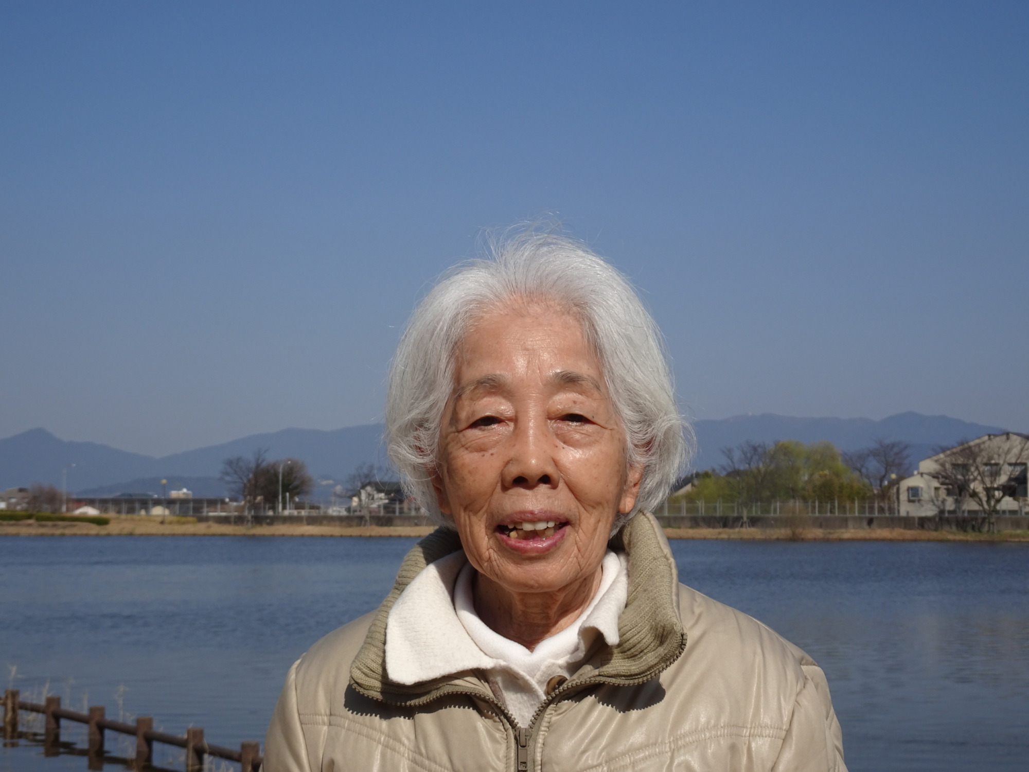 池と青空をバックに写る利用者さん