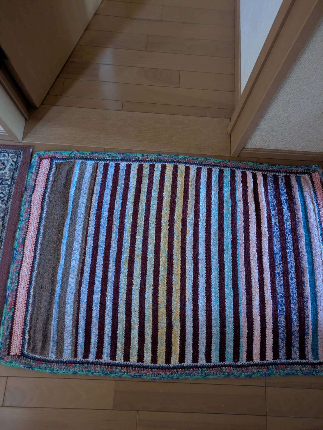 利用者様が編まれた長方形ラグが廊下に敷かれている