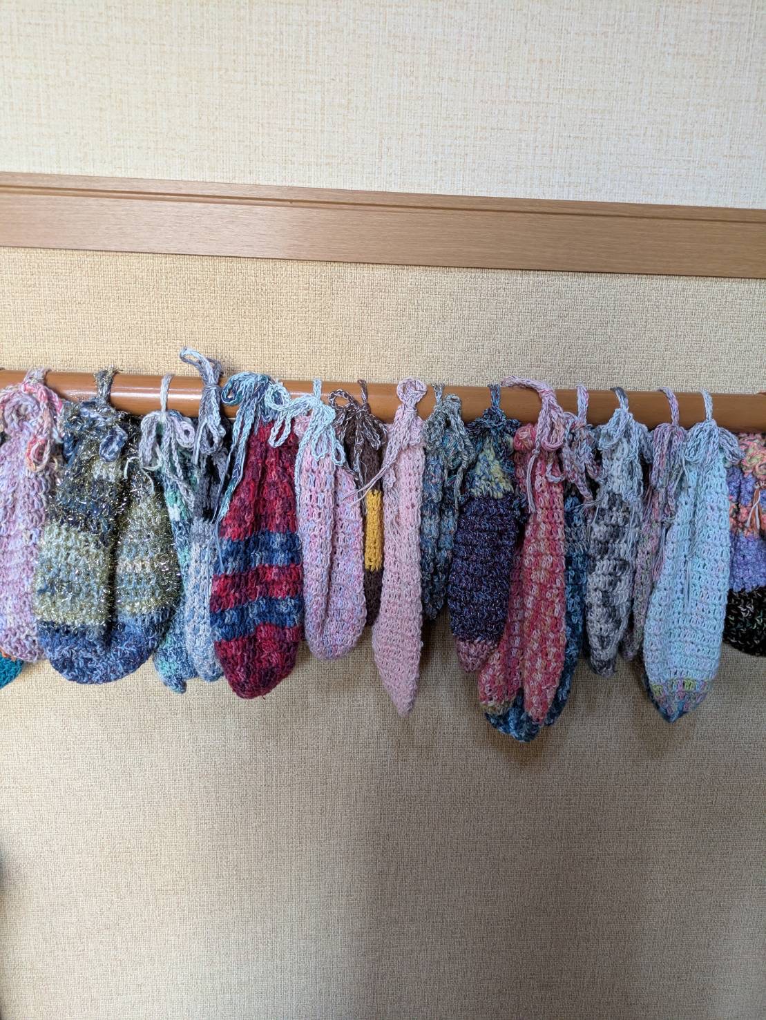 利用者様が編まれた小さな手提げ袋がたくさん飾ってある
