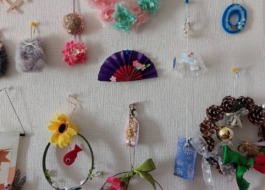 利用者様のお部屋の壁にデイサービスで作られたお花やリース等が飾られている