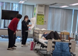 介護教室で講師がおむつやパットを見せながら説明している