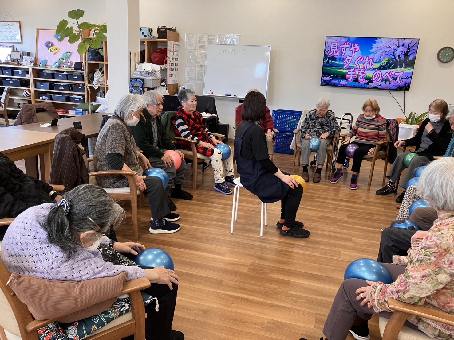 ボールを膝に挟んで足の運動をされている高齢者