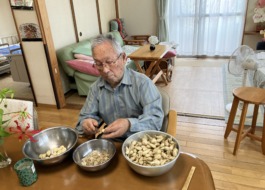 らっきょうの皮剥きをする男性利用者さま