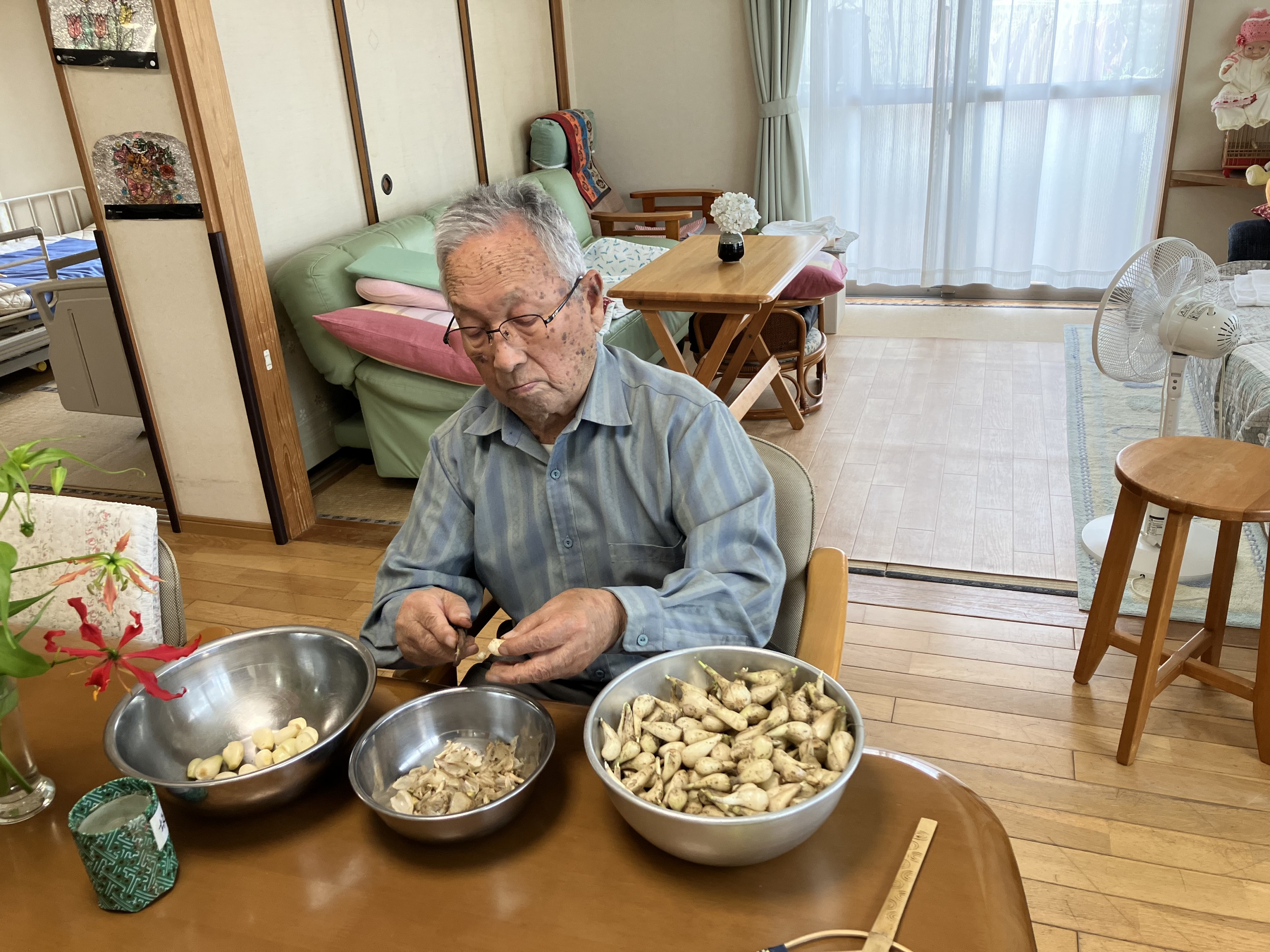 らっきょうの皮剥きをする男性利用者さま