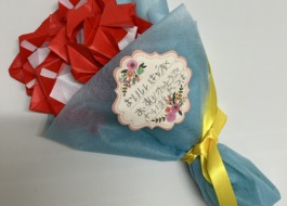 「おいしいきゅうしょくありがとうございました。つき」のメッセージ付きの折り紙の花束の写真