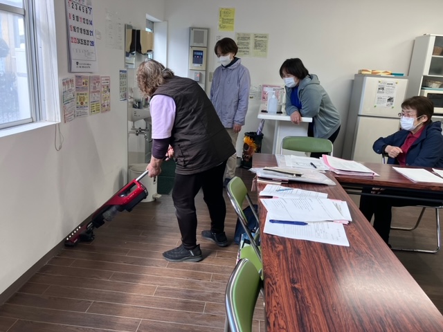 ワーカーが壁に向かって掃除機をかけている