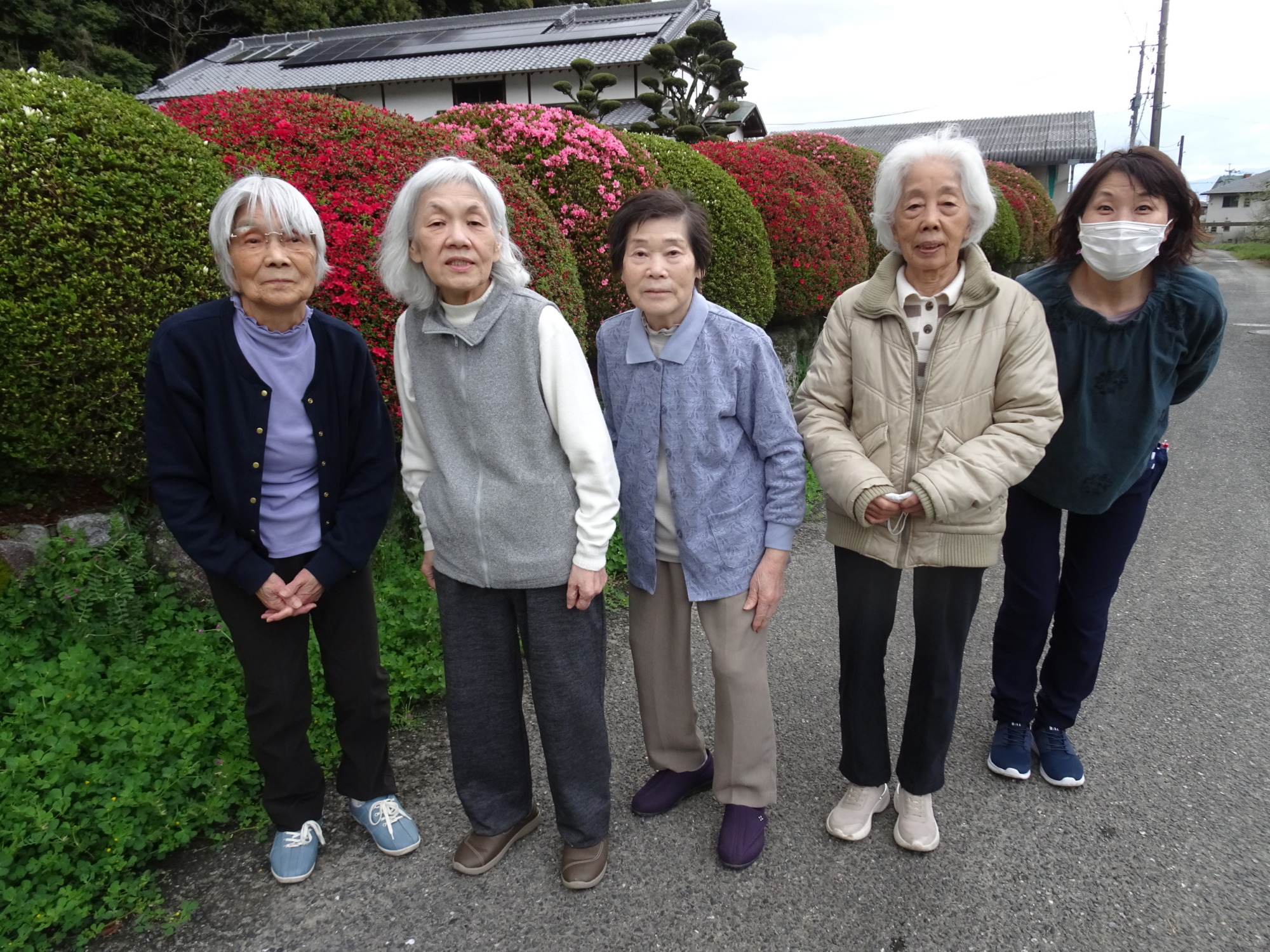 ツツジの前で撮った利用者さんたちとワーカーの写真