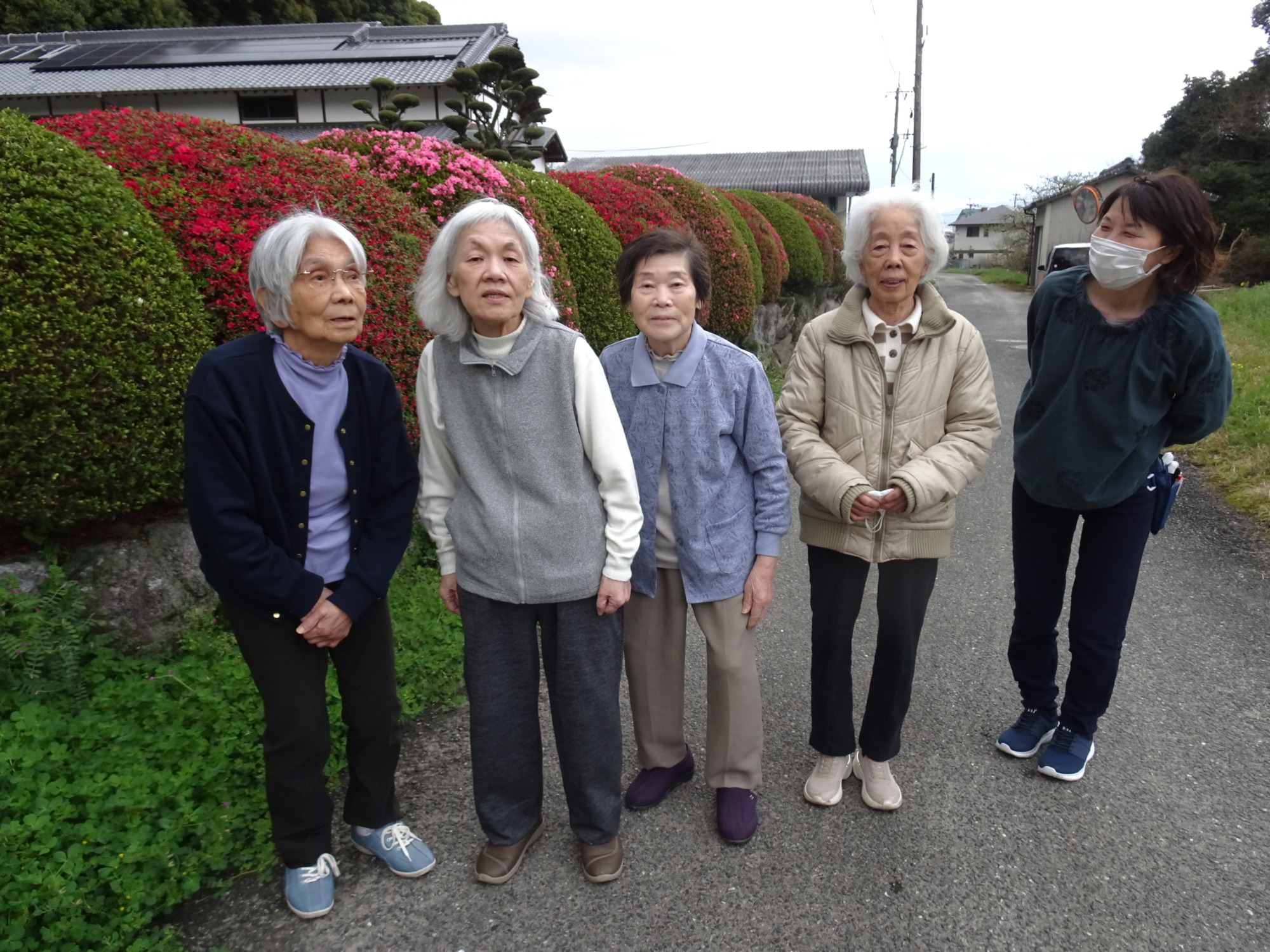 ツツジの前で撮った利用者さんたちとワーカーの写真