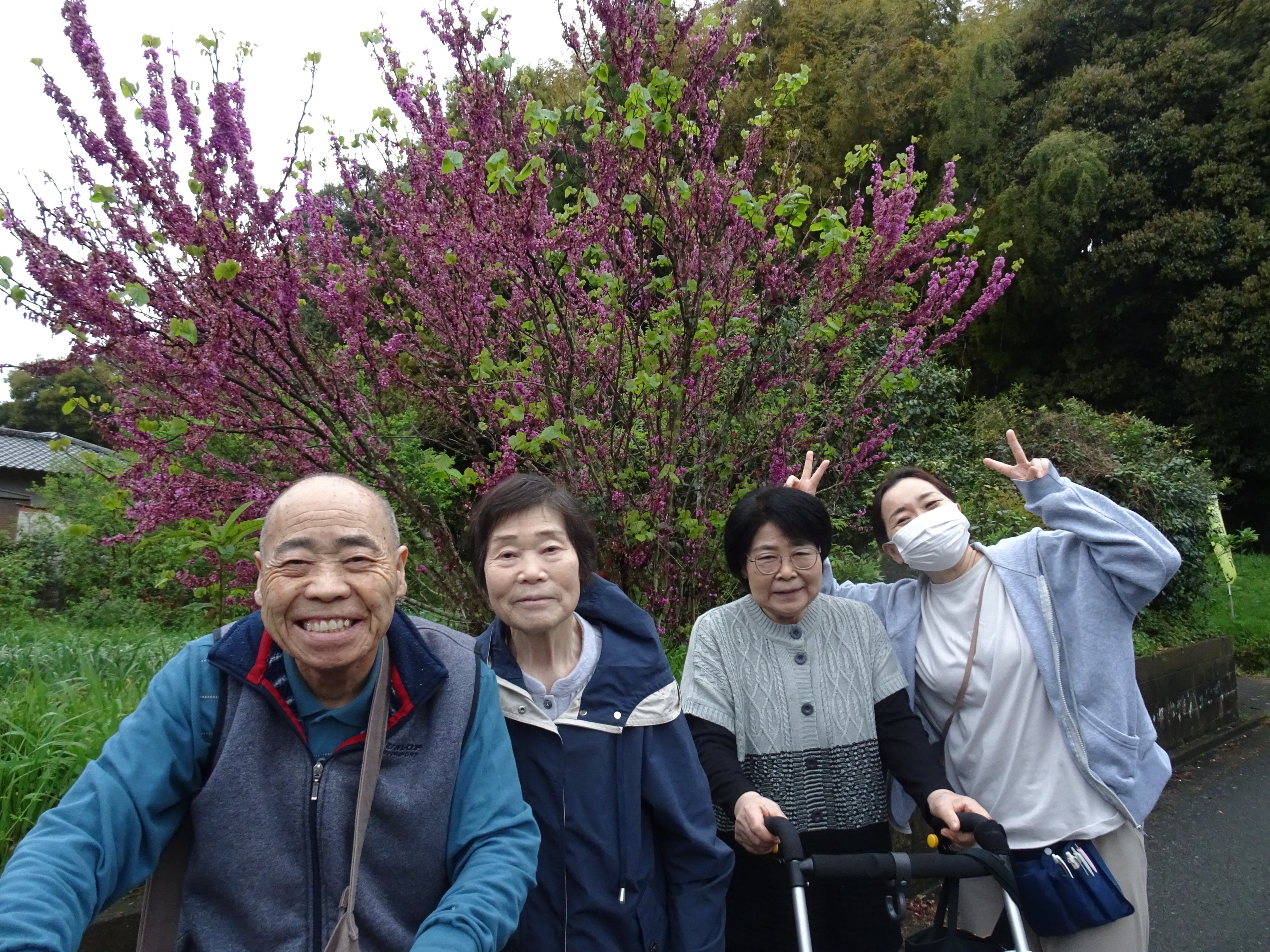 花の前で撮った利用者さんたちとワーカーの集合写真