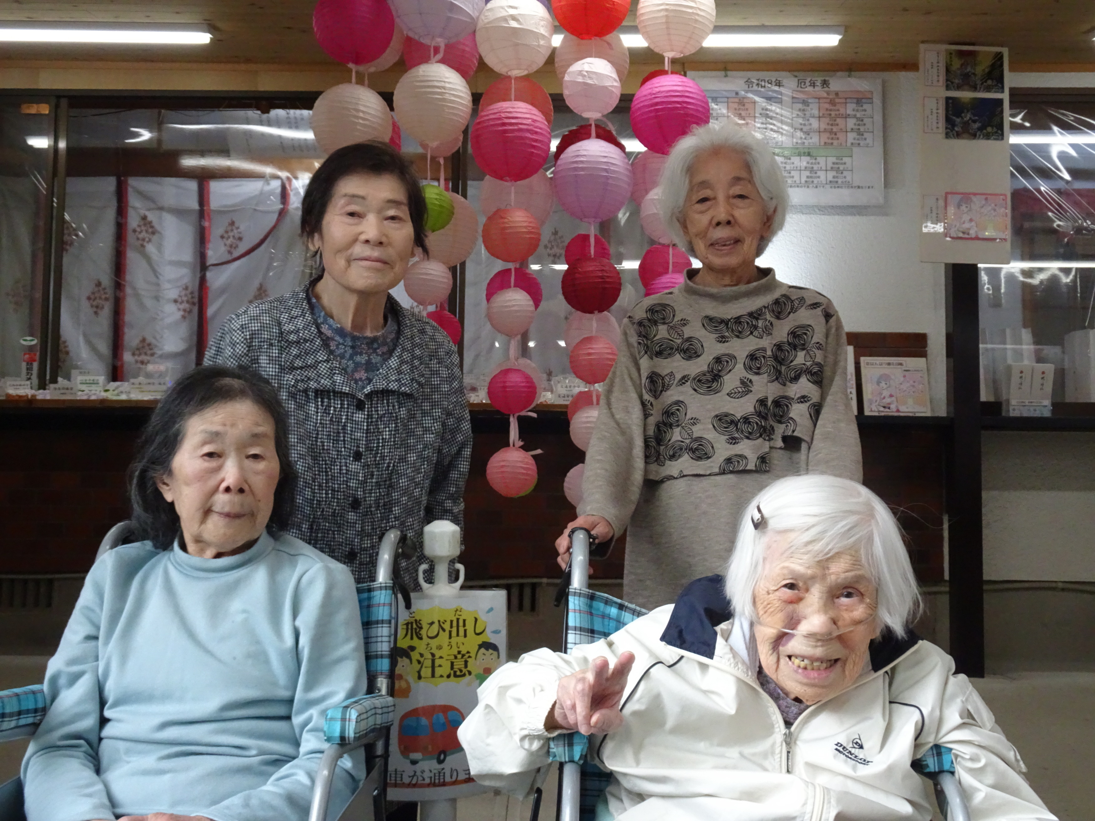 あらひと神社の社務所に飾られたぼんぼりの前で撮った利用者さんたちの写真