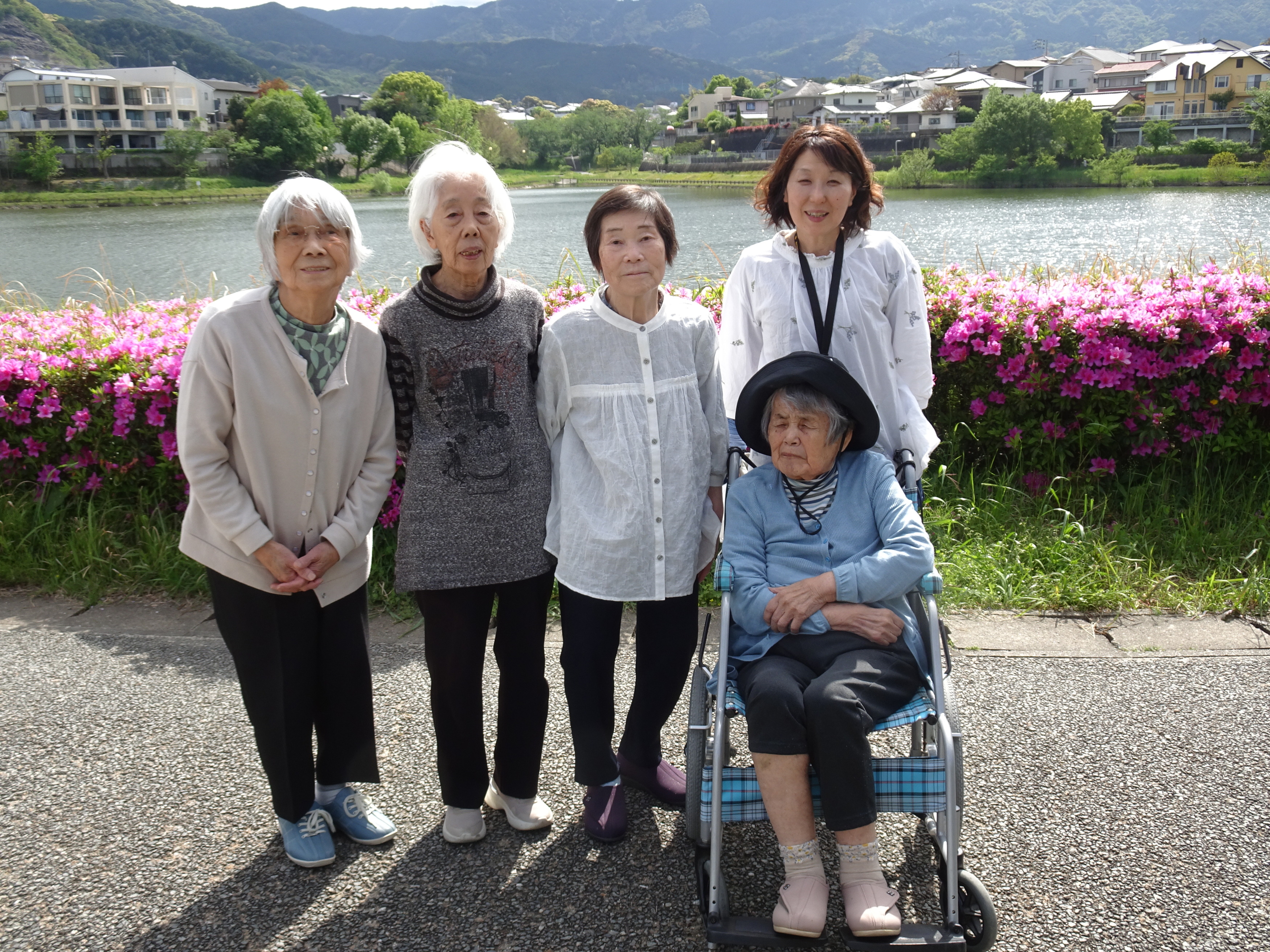 ツツジの前で撮った利用者さんたちとワーカーの写真