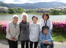 ツツジの前で撮った利用者さんたちとワーカーの写真