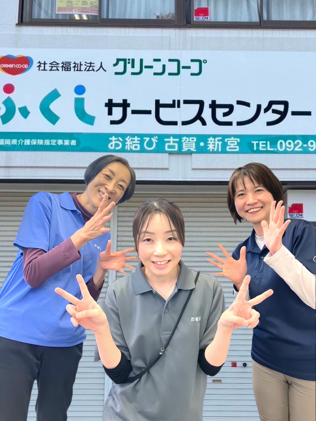 事業所に戻ってきたワーカーが真ん中で笑顔でピースサイン。両脇にサービス提供責任者2人が笑顔で見守っている