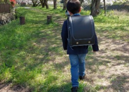 ワーカーの子どもがランドセルを背負って歩いている後ろ姿