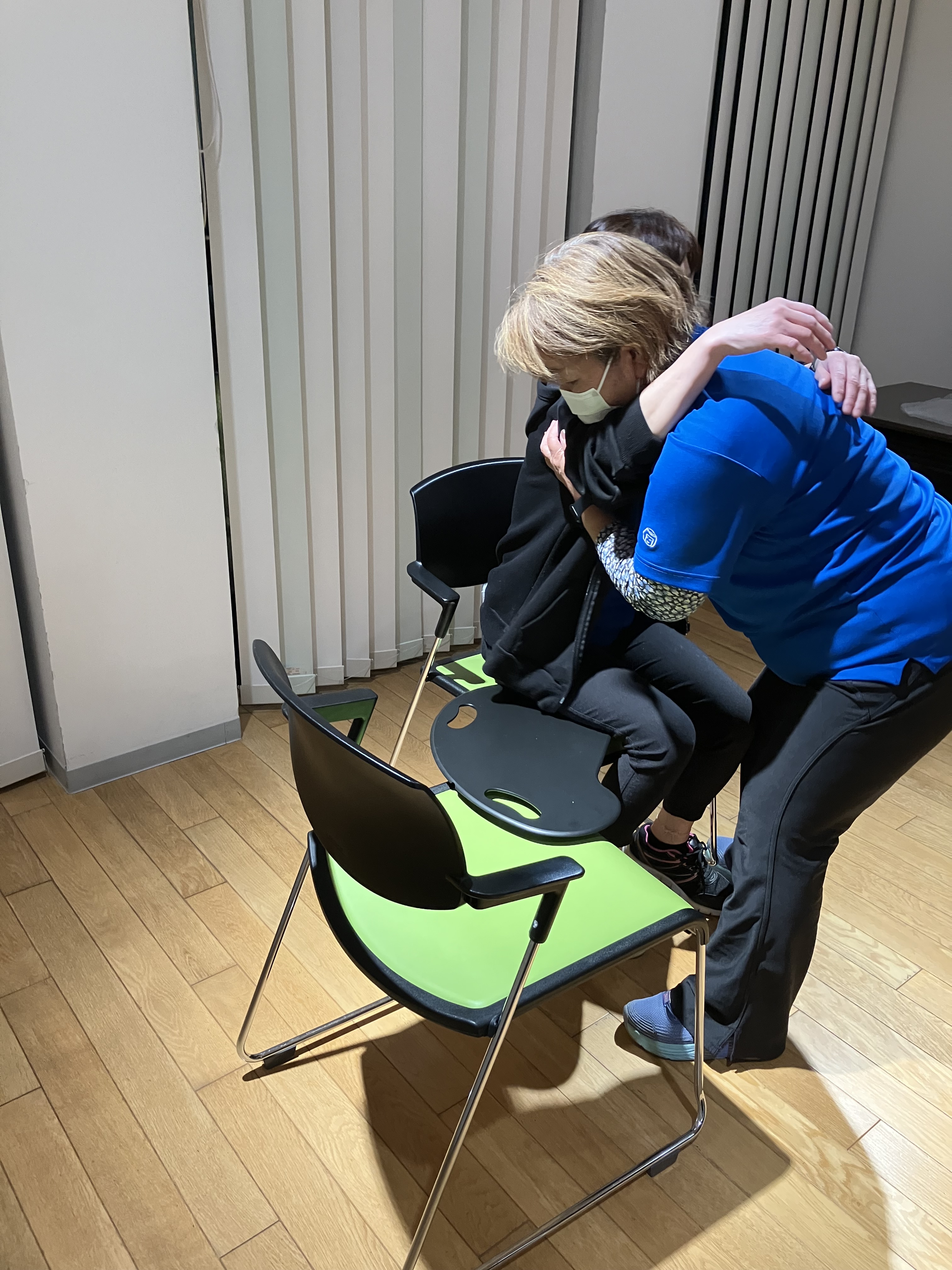 ワーカーがバイキングボードを使って利用者様役のワーカーの移乗介助を行っている