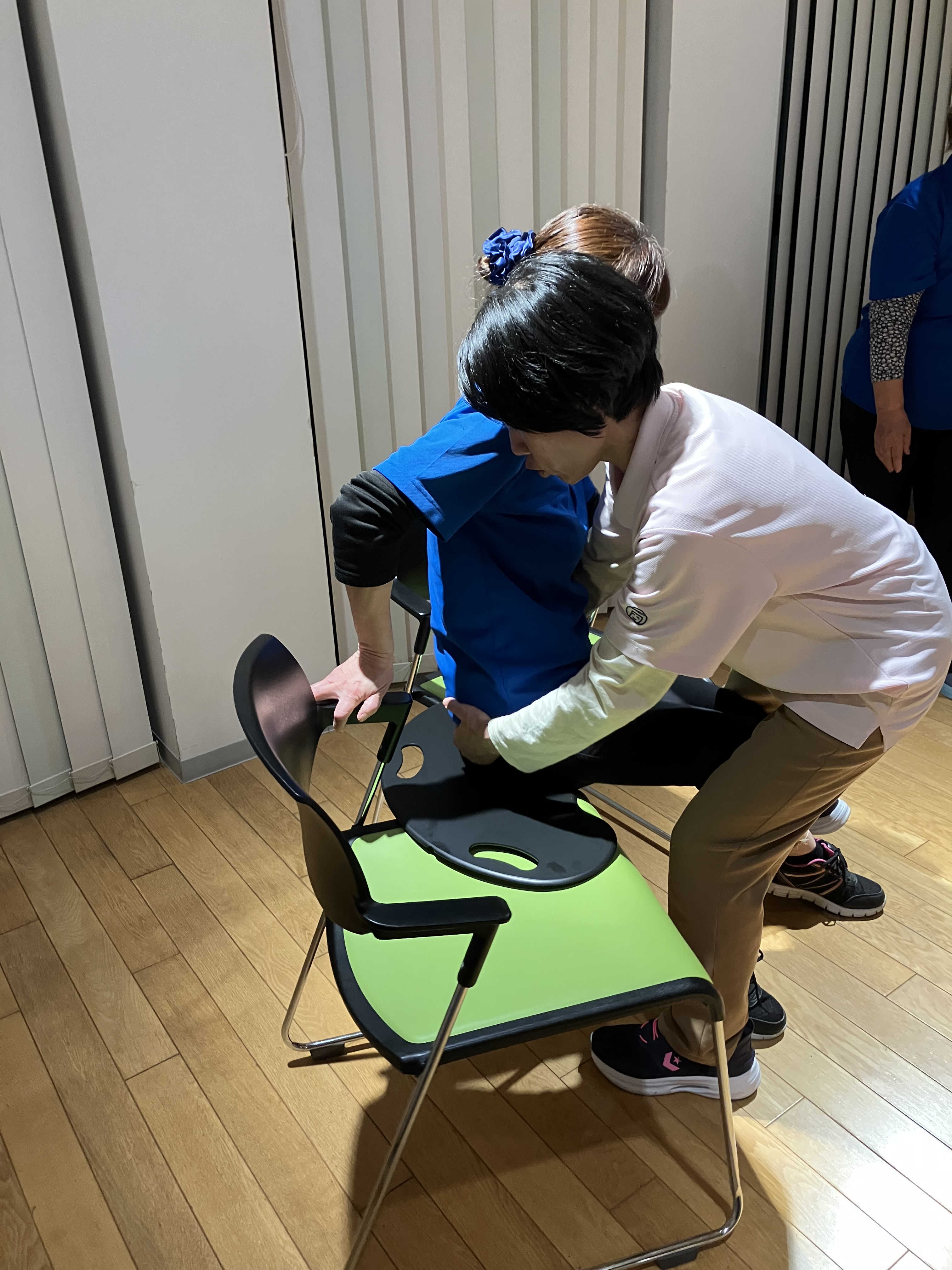 ワーカーがバイキングボードを使って利用者様役のワーカーの移乗介助を練習している