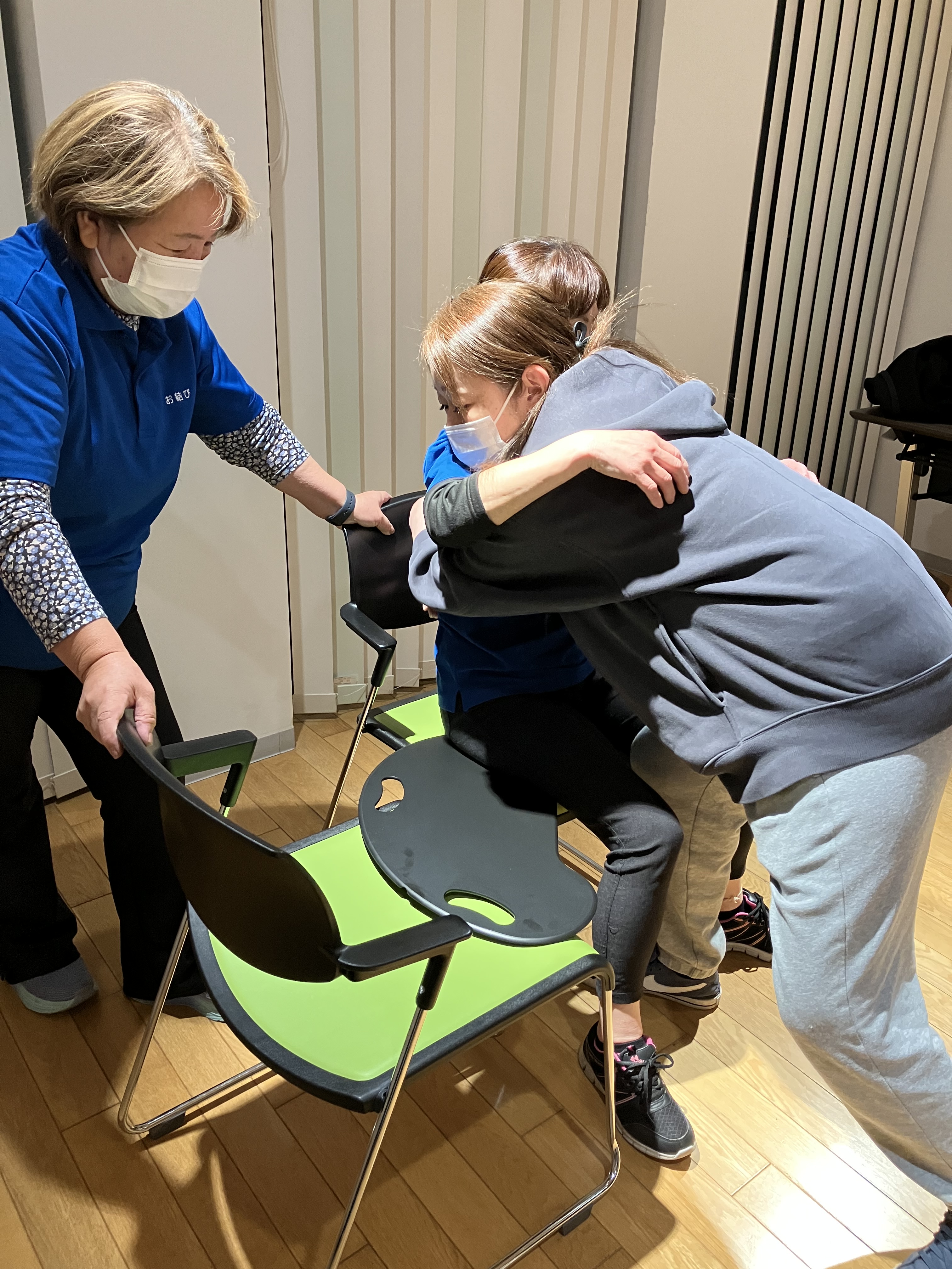 ワーカーがバイキングボードを使って利用者様役のワーカーの移乗介助の練習をしている