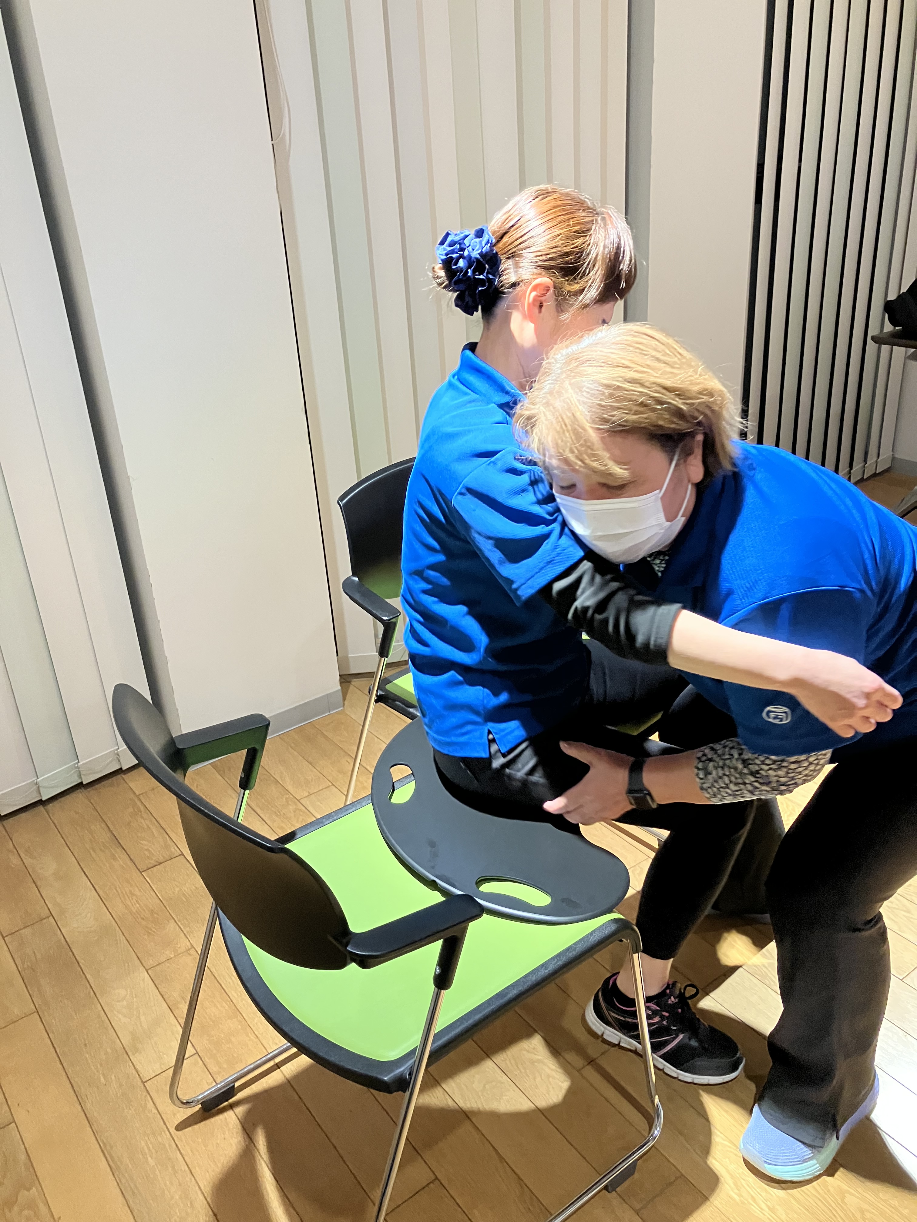 ワーカーがバイキングボードを使って利用者様役のワーカーの移乗介助を行っている