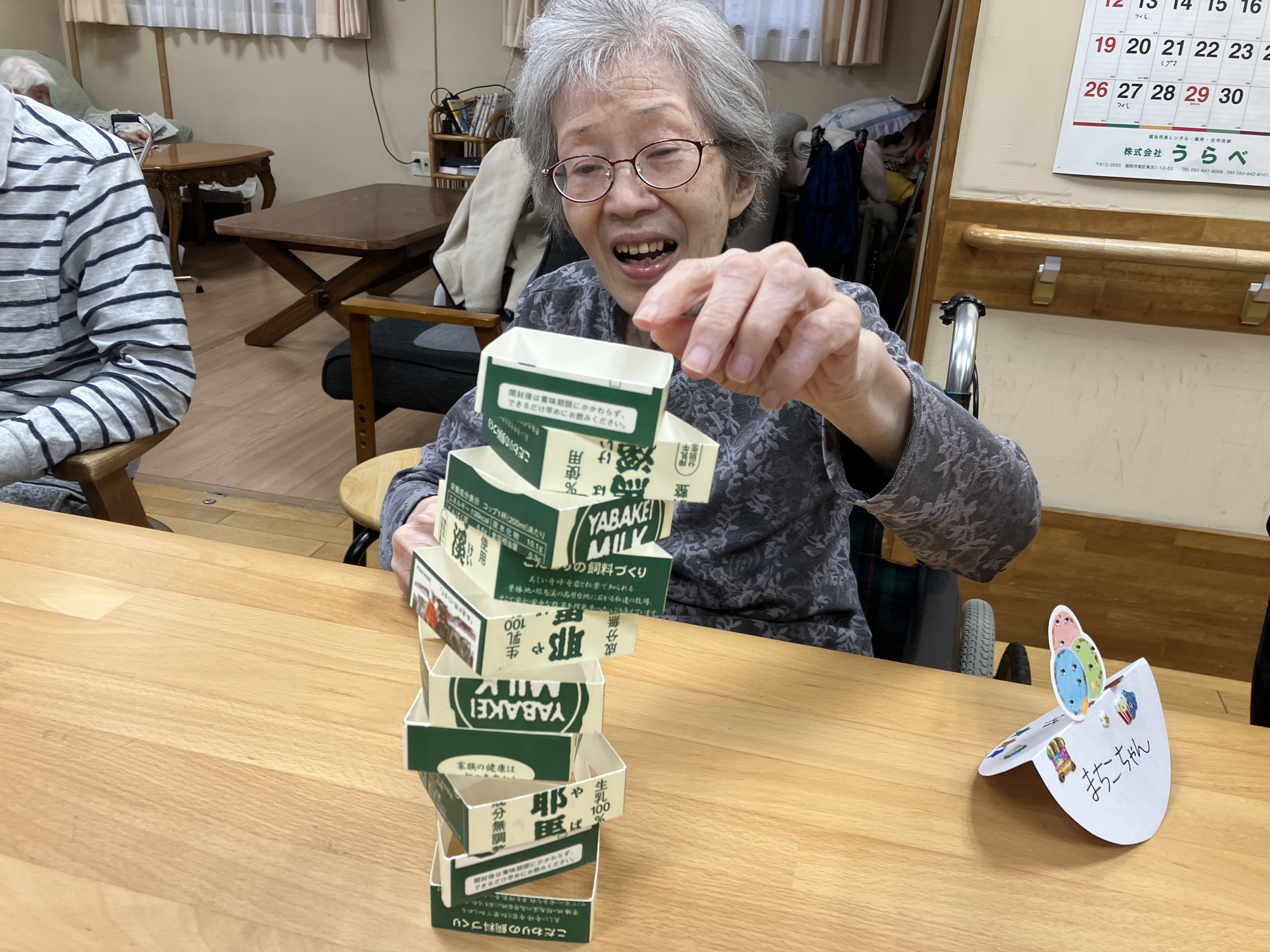 牛乳パックタワーを楽しむ利用者さん